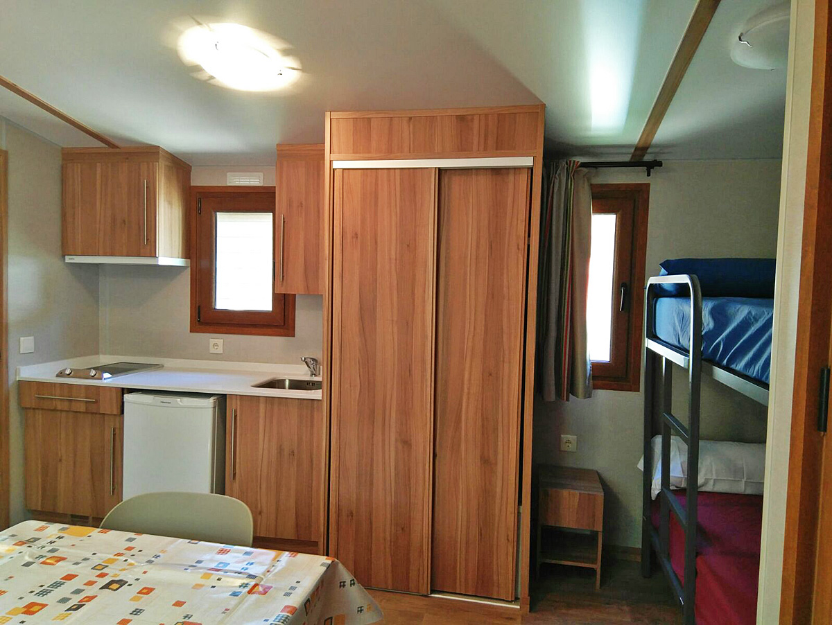 Sala de estar, cocina y cabina con literas